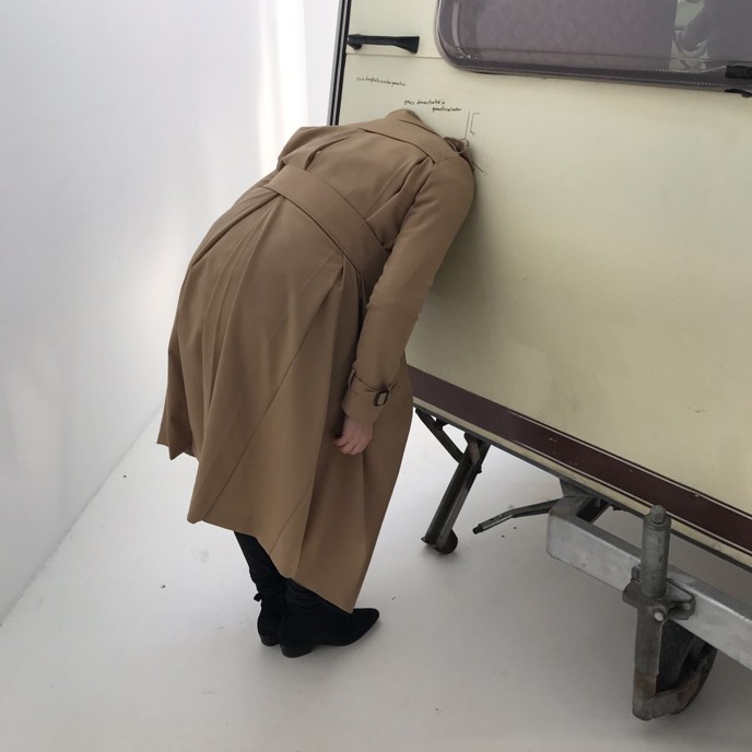 Alex in modern art museum, sticking her head inside a caravan