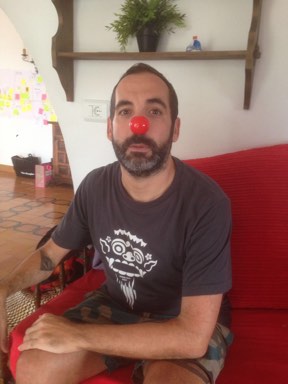Jere wearing a clown's nose sitting on a couch